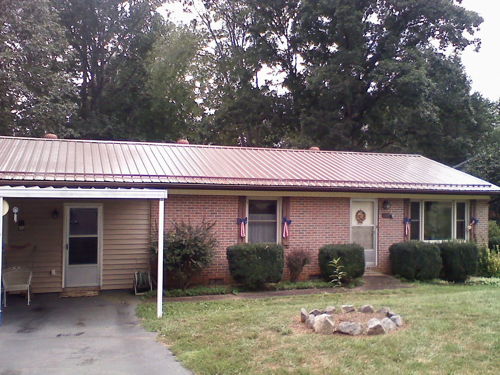 Bronze metal roof and carport on a brick ranch home — Roof Repair work by our crew in Woodridge
